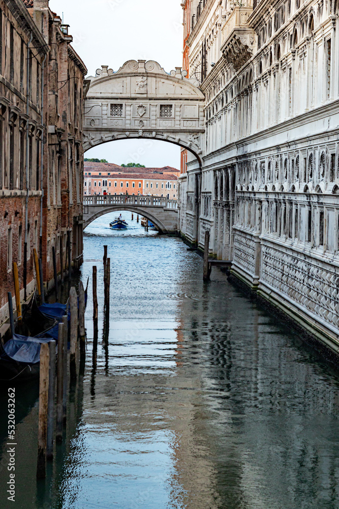 Obraz premium Ponte dei Sospiri (Bridge of Sighs) reflected in calm water in Venice, Italy; at sunrise.