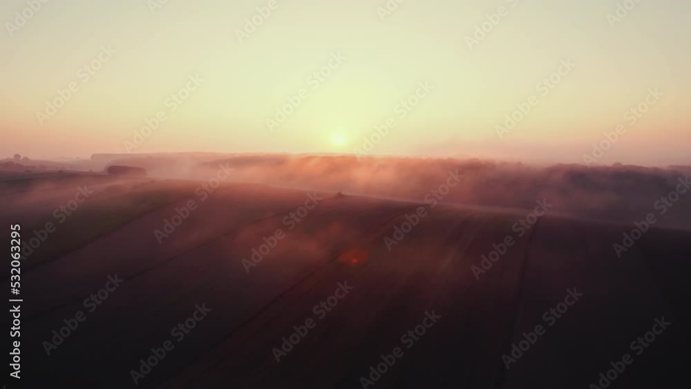 Bright orange rising sun over forest and farm field covered in thick morning fog. Roztocze Poland. Horizontal shot. High quality 4k footage Bright orange rising sun over forest and farm field covered in thick morning fog. Roztocze Poland. Horizontal shot. High quality 4k footage