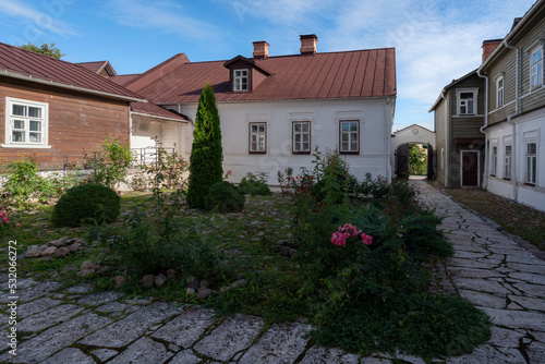 View of the courtyard of a traditional merchant's estate on the main street of Izborsk Pechorskaya Street on a summer cloudy day, Izborsk, Pskov region, Russia photo