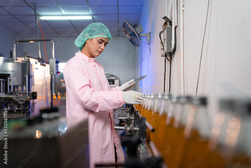 Woman Quality Control a fruit drink factory in glass bottles Inspecting glass bottle packaging for fruit juice drinks, Worker QC working in a drink water factory Woman Quality Control a fruit drink factory in glass bottles Inspecting glass bottle packaging for fruit juice drinks, Worker QC working in a drink water factory