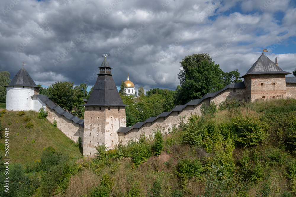 View of the wall of the Holy Dormition Pskov-Pechersk Monastery, the Tower of the Upper Lattices, Tailovskaya tower and Tararygin Tower on a sunny summer day, Pechory, Pskov region, Russia