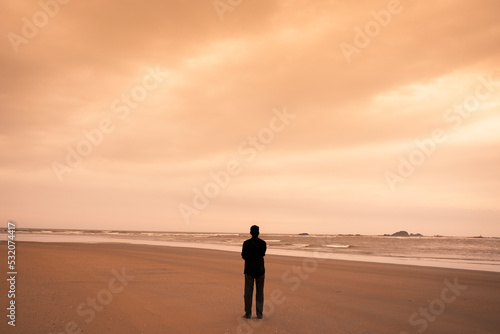 a young man spending time alone on the beach 