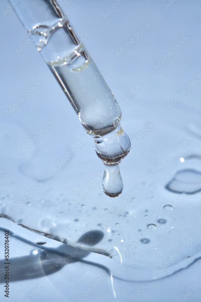 Dropper with serum or cosmetic oil on a blue background. Dropper with serum or cosmetic oil on a blue background.
