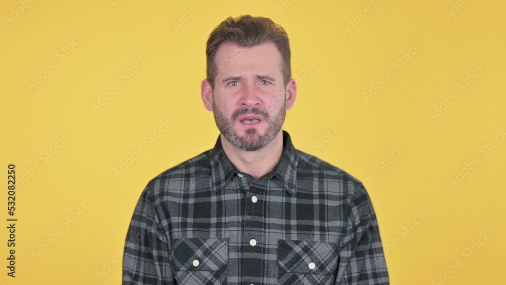 Sadd Middle Aged Man Reacting to Failure, Yellow Background Sadd Middle Aged Man Reacting to Failure, Yellow Background