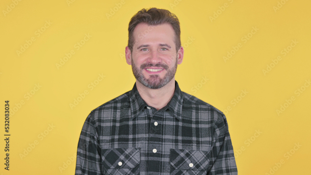 Middle Aged Man Smiling at Camera, Yellow Background Middle Aged Man Smiling at Camera, Yellow Background