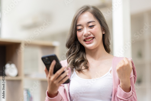 Excited happy Asian woman looking at the phone screen, celebrating an online win, overjoyed young asian female screaming with joy, isolated over a white blur background Free Download Excited happy Asian woman looking at the phone screen, celebrating an online win, overjoyed young asian female screaming with joy, isolated over a white blur background - GFXLoad