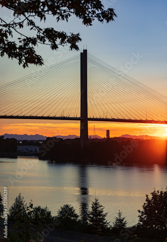 River and bridge at beautiful summer sunset. A view of the Alex Fraser Bridge from North Delta BC