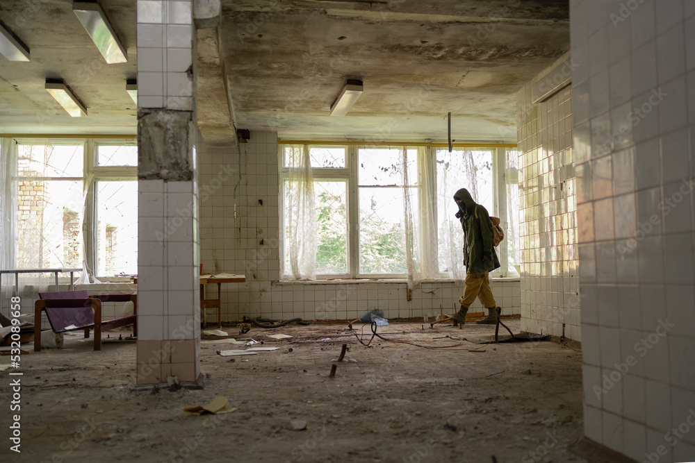 Man walking in an abandoned building. wandering men. man in a cloak with a hood. Post apocalypse. traveling on foot in a post-apocalyptic world. Man walking in an abandoned building. wandering men. man in a cloak with a hood. Post apocalypse. traveling on foot in a post-apocalyptic world.