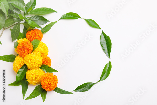 Indian festival dussehra greeting. green leaf with marigold flower on white background. photo