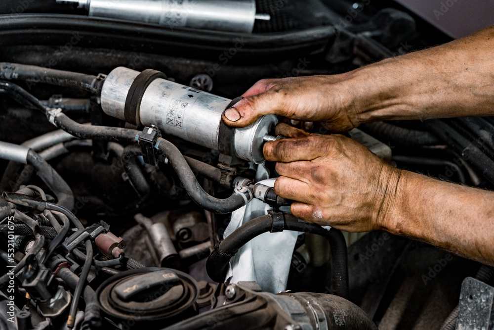 Obraz premium Close up of auto mechanic repairing car engine in car service