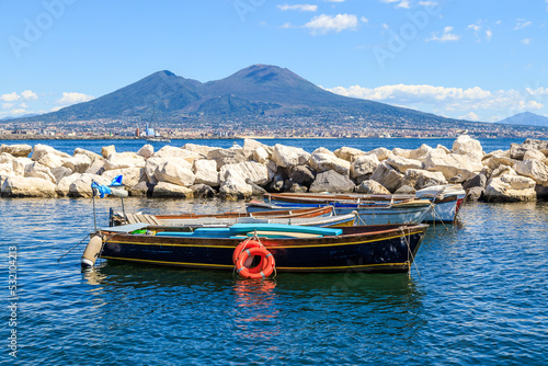 Vesuvius volcano view from gulf of Naples, Italy. Wood boats in the pier. photo