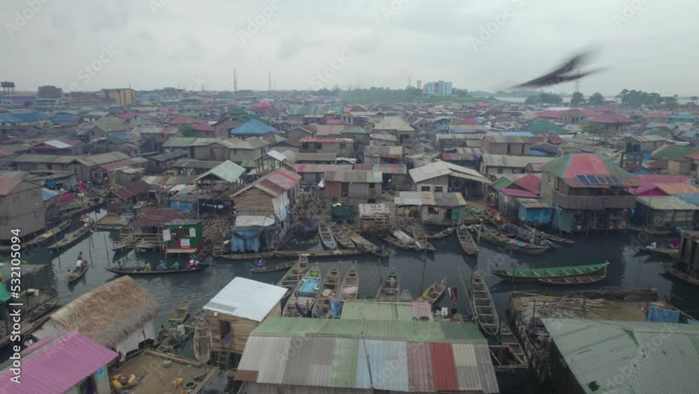 Houses build on a slum people paddling a canoe Houses build on a slum people paddling a canoe