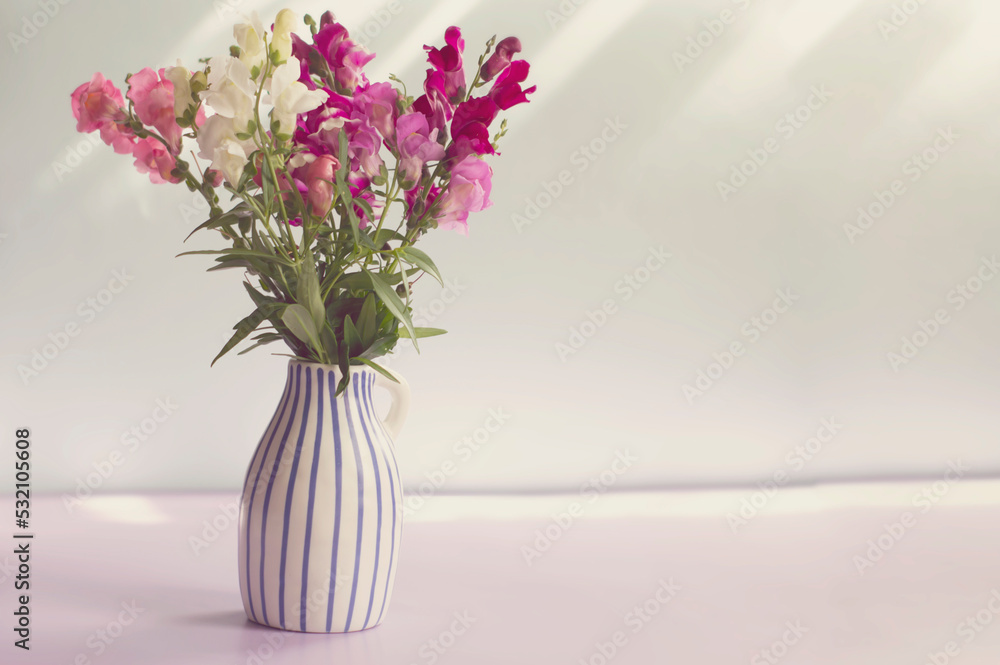 Naklejka premium Bouquet of flowers of Antirrhinum majus in a vase.