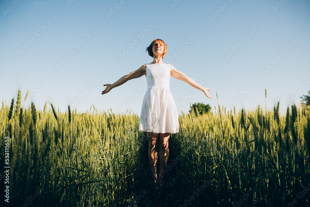 Young beautiful girl poses in a wheat field in the summer Young beautiful girl poses in a wheat field in the summer