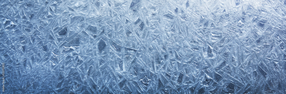 The texture of the ice surface. Winter background, festive background in the form of ice crystals, in natural deep blue color. The texture of the ice surface. Winter background, festive background in the form of ice crystals, in natural deep blue color.