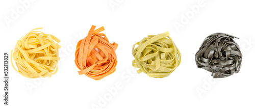 Foto Tagliatelle pasta in different colors, twisted into nests, from above, isolated, over white