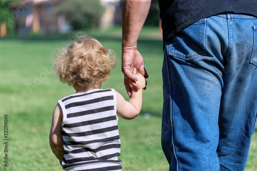 Slika na platnu Man kidnapping little toddler or boy walking holding hands with his grandpa at p