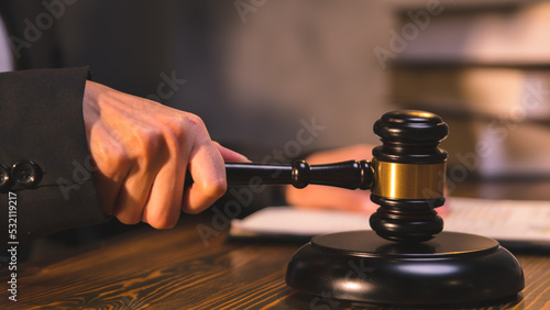 Wallpaper Mural A person holding a judge's hammer, a lawyer reading the law and preparing documents in the office, legal and litigation consulting services. Torontodigital.ca