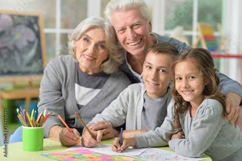 Portrait of grandparents and grandchildren drawing at home