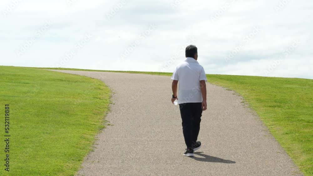 公園でウォーキング・有酸素運動する高齢者男性
