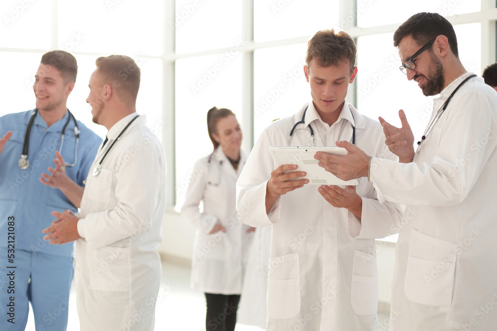 medical professionals looking at the screen of a digital tablet