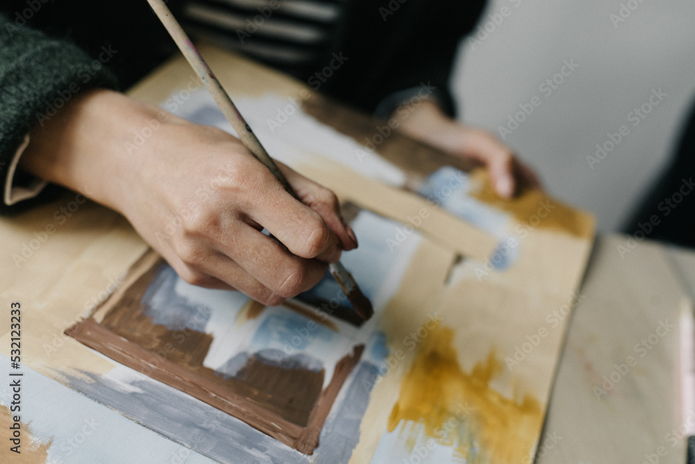 Woman paints with a brush paints on a sheet