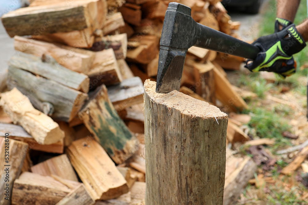 hands with an ax splitting firewood. renewable and sustainable energy concept hands with an ax splitting firewood. renewable and sustainable energy concept