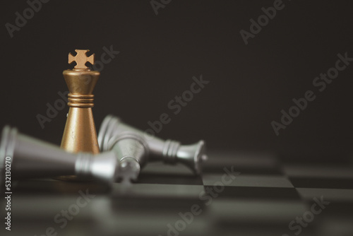 Фотография Golden knight stand as last winner over silver chess on chess board