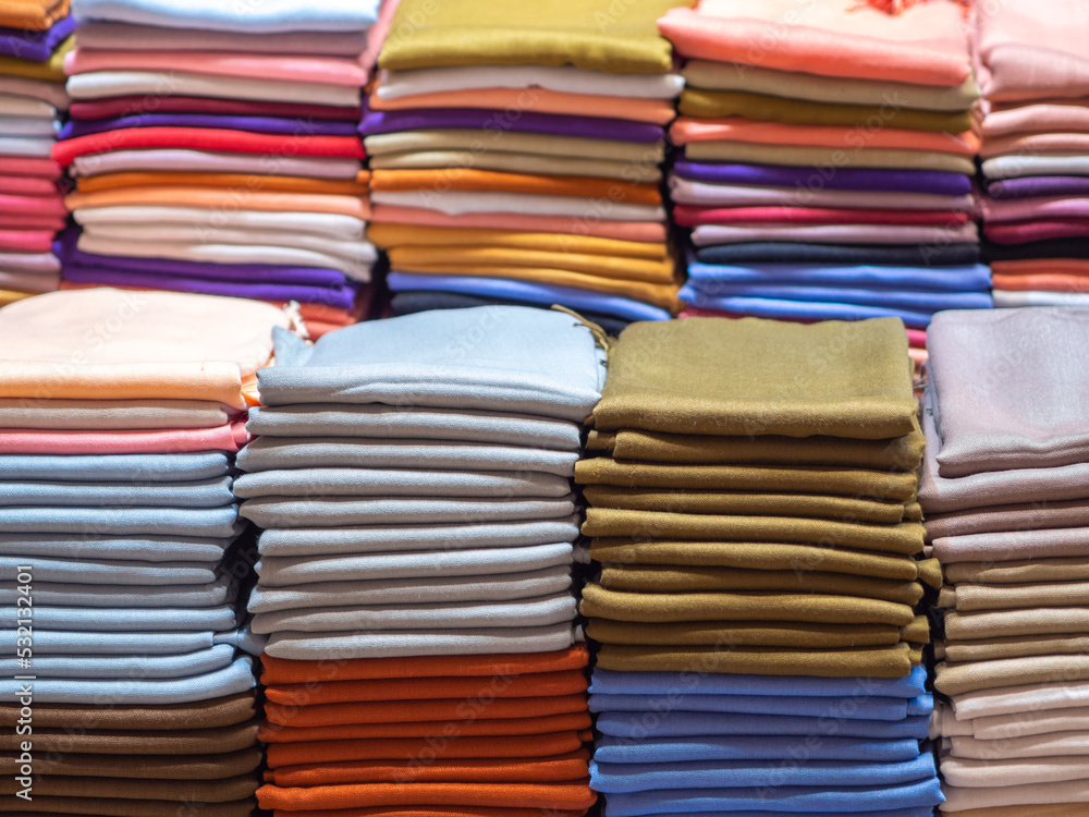 Pile of folded colorful textile. Heap of cloth fabrics. Arab textile production Pile of folded colorful textile. Heap of cloth fabrics. Arab textile production