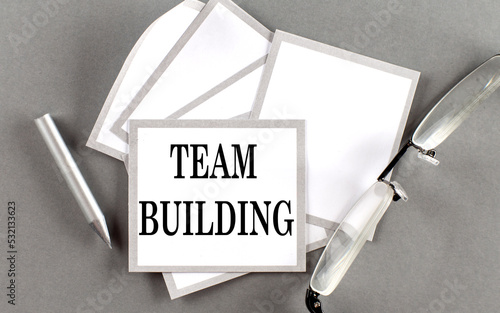 TEAM BUILDING text written on a sticky with pencil and glasses photo