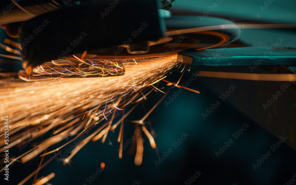 flying sparks from grinding metal, work with a manual grinder, closeup shot - obrazy, fototapety, plakaty 