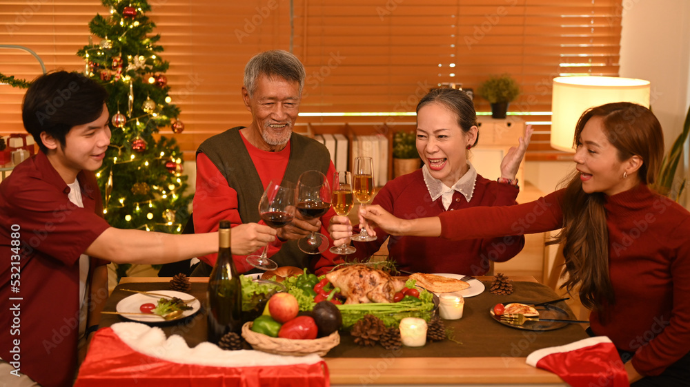Image of happy family celebrating Christmas together at home lighted with soft lights and candles. Celebration, holidays and people concept