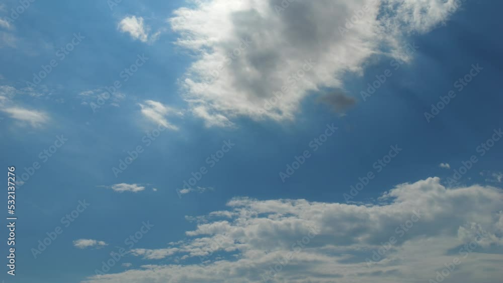 Light white clouds fly over a bright blue sky. Clear sky in sunny summer afternoon. Spring cloudy landscape background. copy space Light white clouds fly over a bright blue sky. Clear sky in sunny summer afternoon. Spring cloudy landscape background. copy space