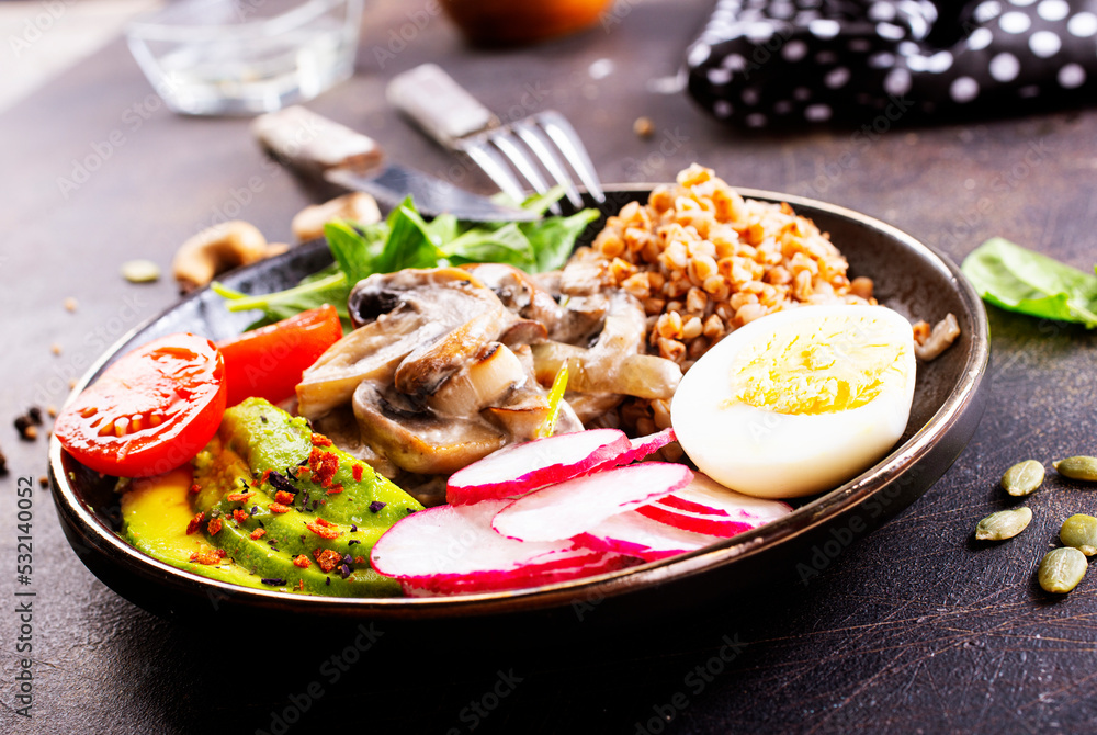 Cooked Buckwheat with avocado and mushrooms served in a bawl for breakfast. Gluten free meal. Cooked Buckwheat with avocado and mushrooms served in a bawl for breakfast. Gluten free meal.