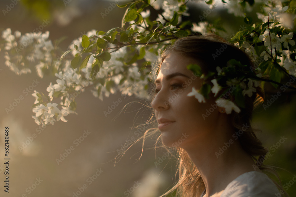 closeup sideview portrait of looking away attractive caucasian woman among the flowering apple tree closeup sideview portrait of looking away attractive caucasian woman among the flowering apple tree
