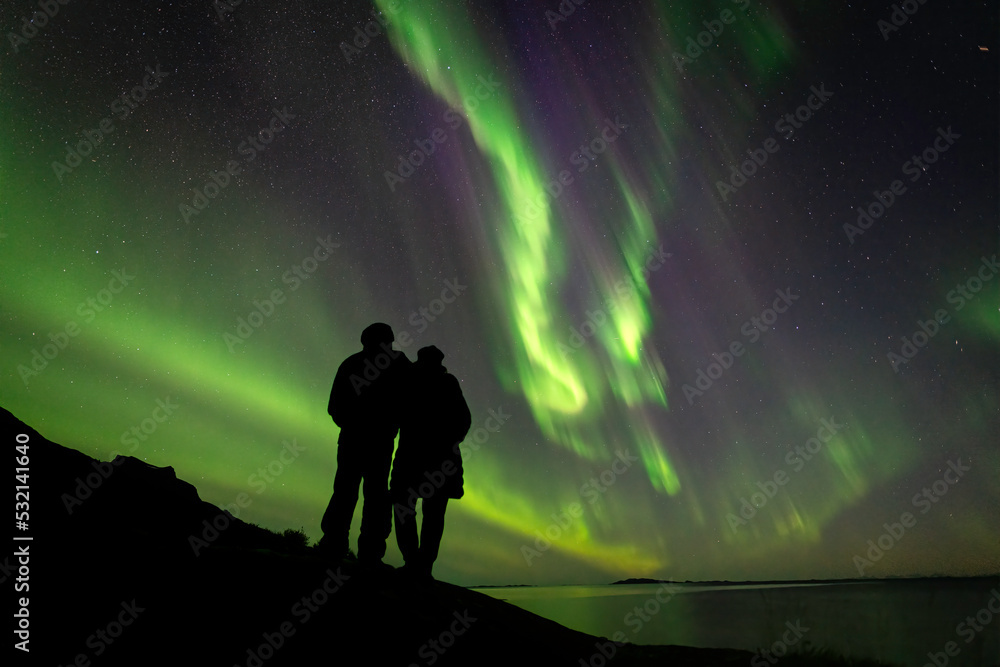 silhouette of a couple watching  Aurora Borealis