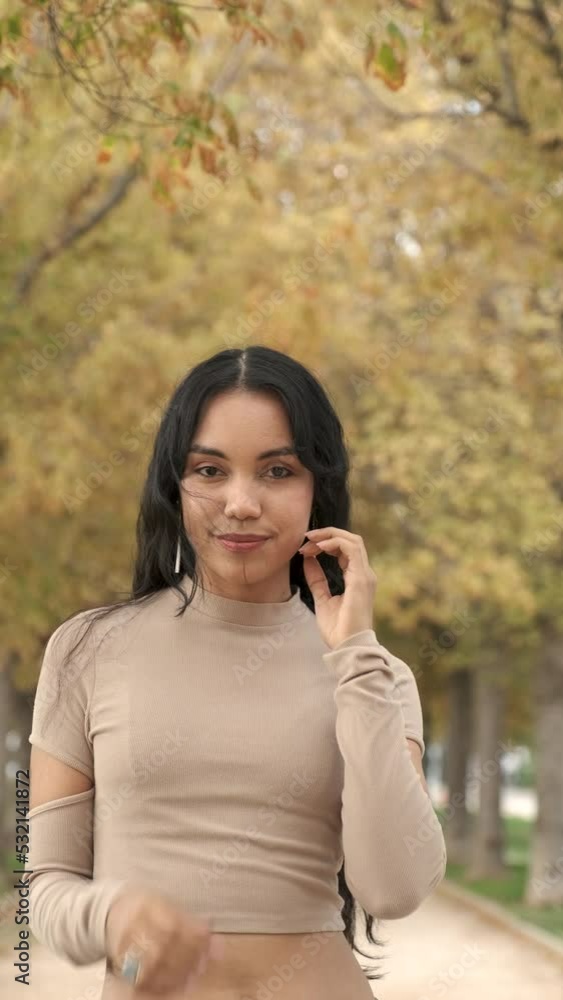 Young latin girl turning around, looking at camera and smiling at street in autumn. Young latin girl turning around, looking at camera and smiling at street in autumn.