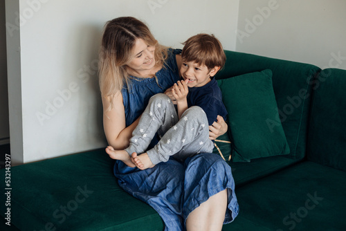 Obraz na plátne Blond smiling, cheerful and kind woman and boy, her son playing and embracing, tickling together at home