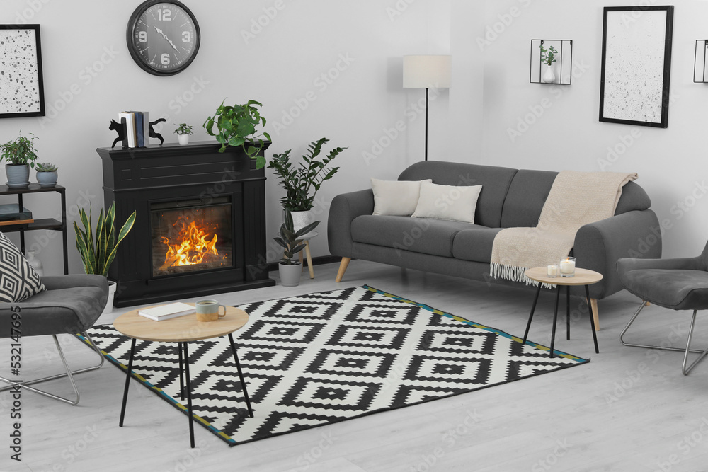 Obraz premium Stylish living room interior with fireplace and comfortable sofa