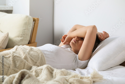 Sleepless young woman in bed at home