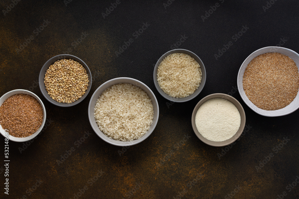 Various grain cereals in bowls, top view on a brown background with bowls of cereals Various grain cereals in bowls, top view on a brown background with bowls of cereals