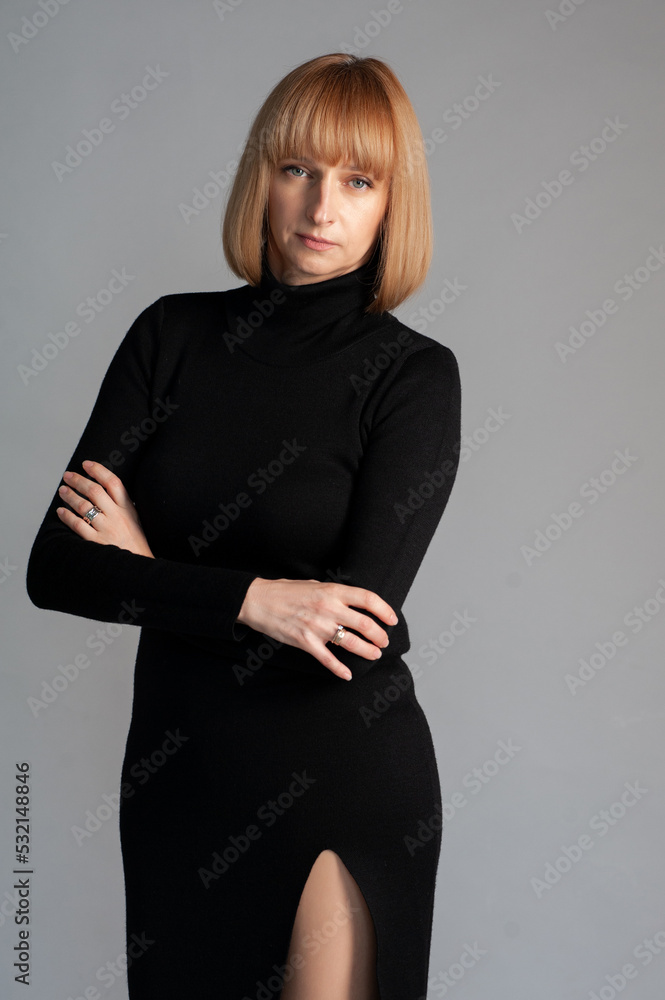 Beautiful blonde businesswoman portrait in black dress on background Beautiful blonde businesswoman portrait in black dress on background
