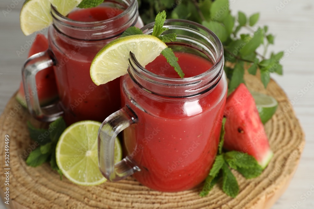 Tasty summer watermelon drink, limes and mint on white wooden table, closeup Tasty summer watermelon drink, limes and mint on white wooden table, closeup