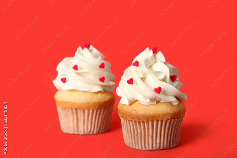 Tasty cupcakes for Valentine's Day on red background Tasty cupcakes for Valentine's Day on red background