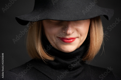 Woman in black dress and hat on background © alipko