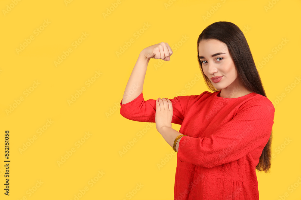 Strong woman as symbol of girl power on yellow background, space for text. 8 March concept