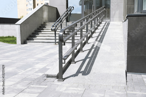 Outdoor stairs with ramp and metal railing photo