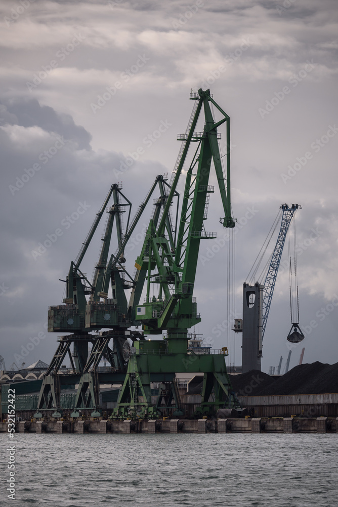 MARITIME TRANSPORT - Port crane on the quay with coal on the reloading yard MARITIME TRANSPORT - Port crane on the quay with coal on the reloading yard