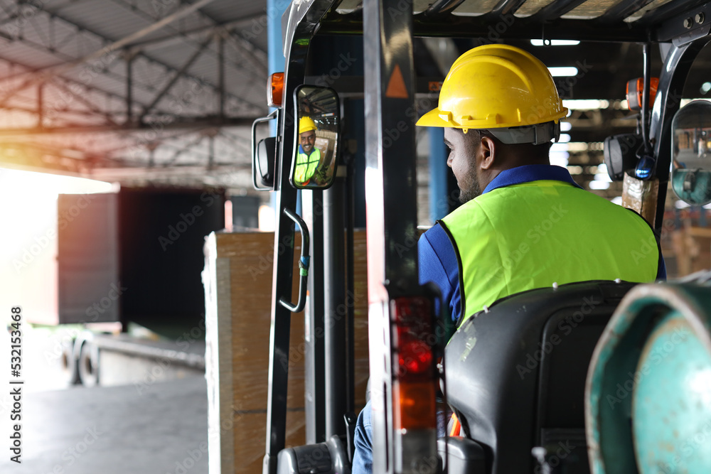 Warehouse workers or forklift driver man with hardhats and reflective jackets in vehicle using walkie talkie radio controlling stock and inventory in retail warehouse logistics, distribution center Warehouse workers or forklift driver man with hardhats and reflective jackets in vehicle using walkie talkie radio controlling stock and inventory in retail warehouse logistics, distribution center