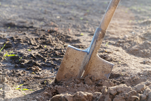 a shovel stuck in the ground at the dacha